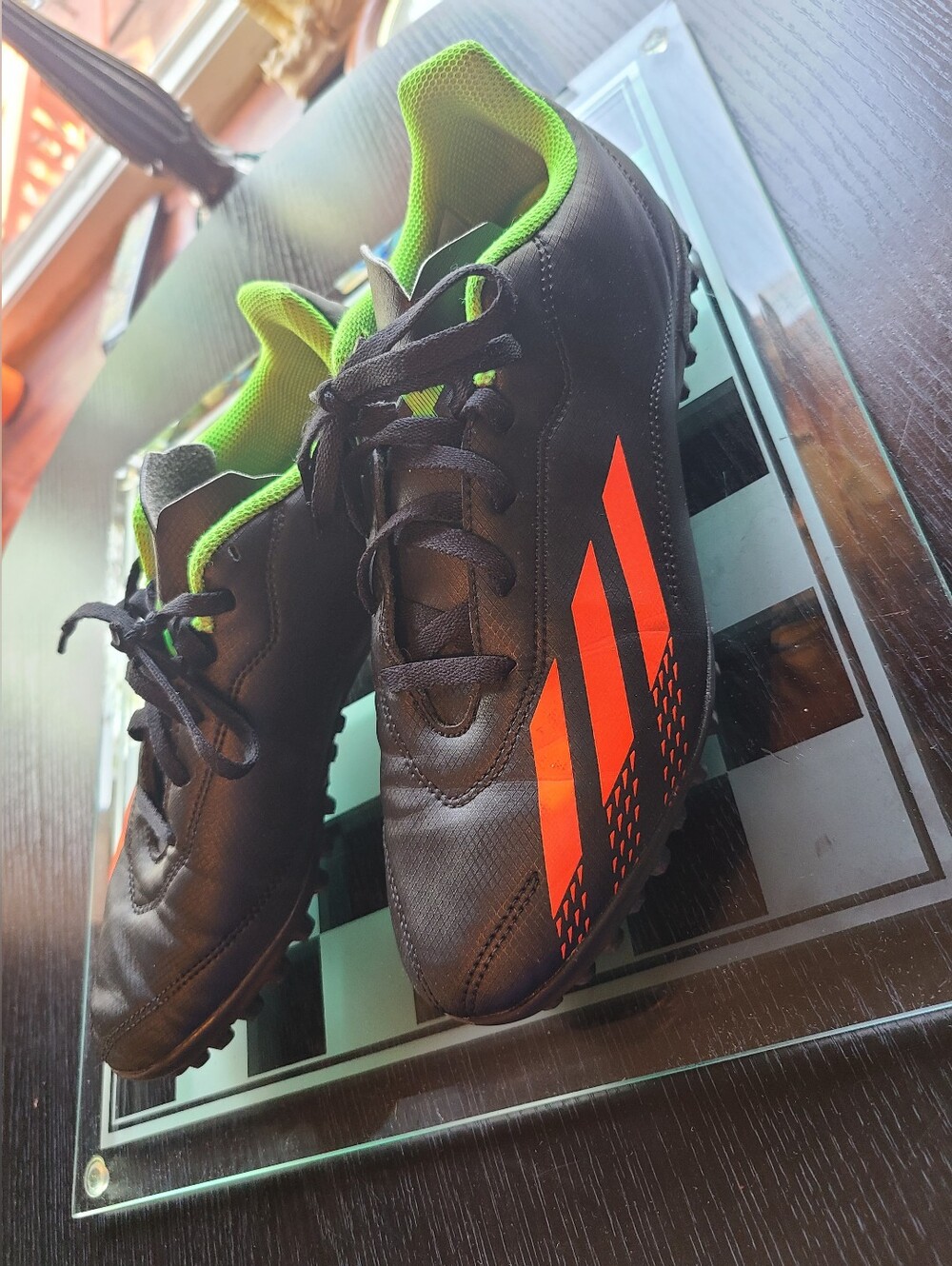 Black Soccer Cleats with Orange Stripes and Green Lining